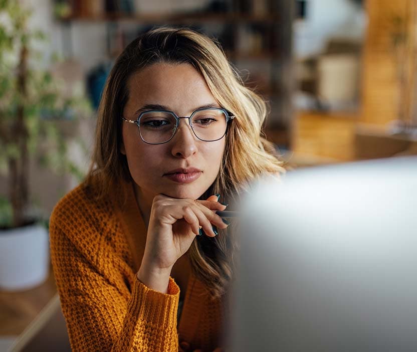 A woman looks at her computer screen and considers her options after a hacker targets her in a ransomware attack. 